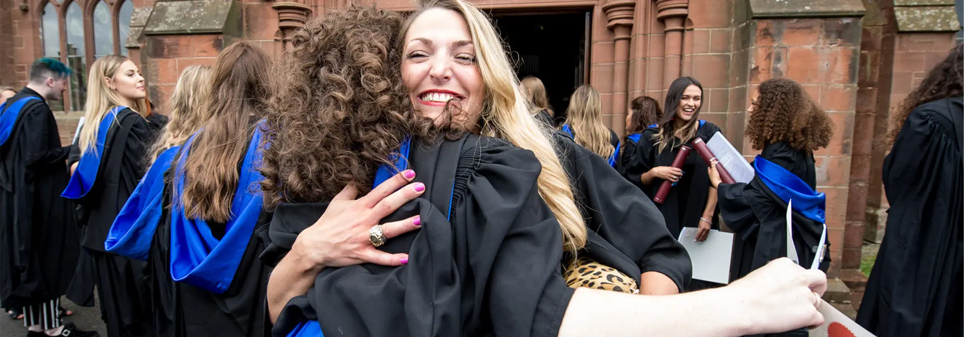Graduates hugging at their graduation day