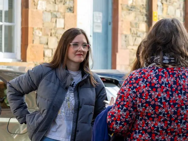 Prospective student at an open day speaking to staff.