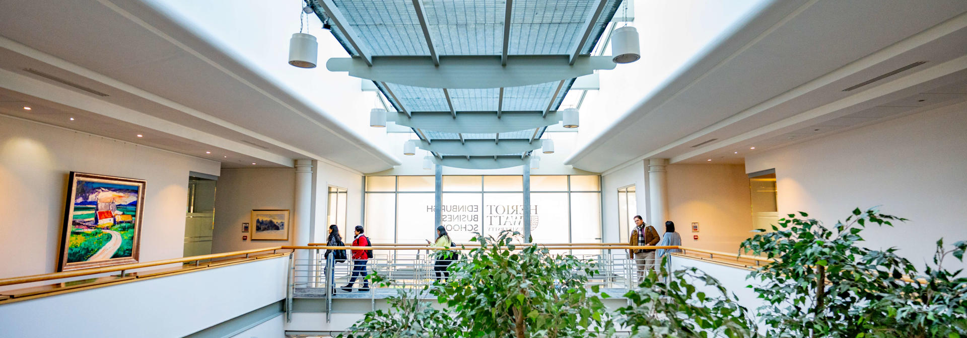 Students walk across the mezzanine floor walkway in Edinburgh Business School