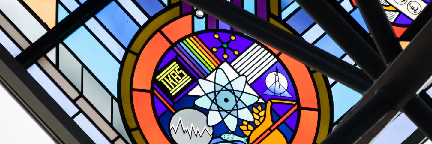 Colourful stained glass window with various symbols for science.