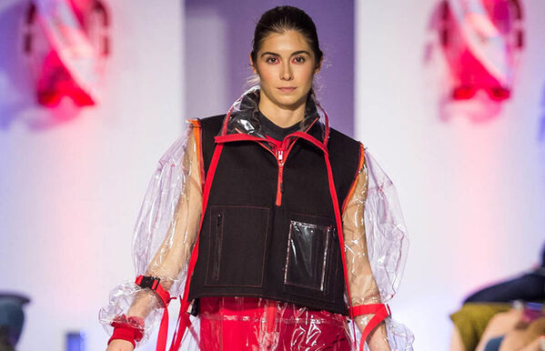 model walking catwalk, wearing long clear coat with red seams and a black under shirt