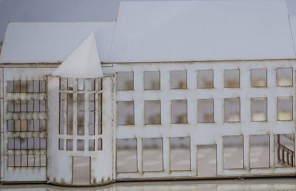 close up of warehouse building made from white paper that is worn around the edges