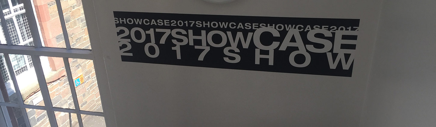 black sign on wall with showcase 2017 written in white