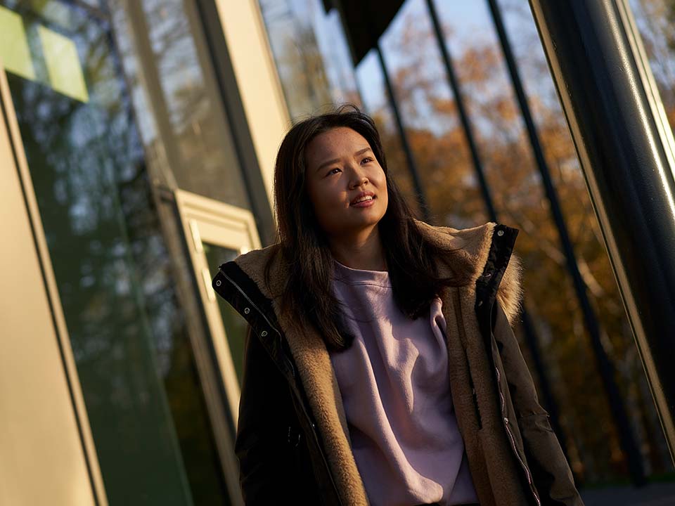 A female student exits the GRID building, Edinburgh Campus