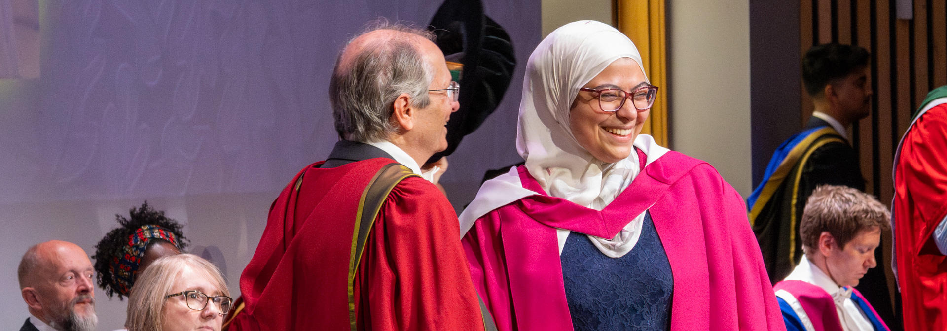 A PhD graduate receives her graduation certificate at the graduation ceremony.
