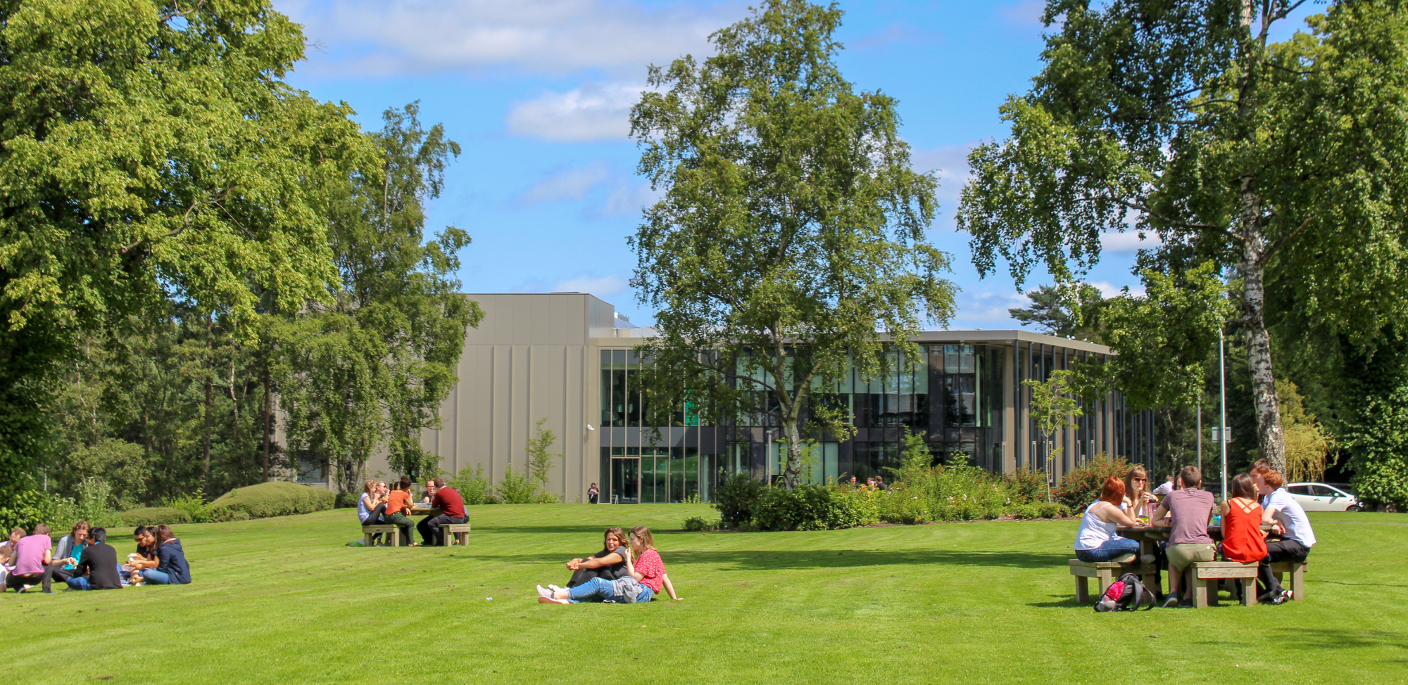 Staff and students sitting out on the lawn on a sunny day at our Edinburgh campus.