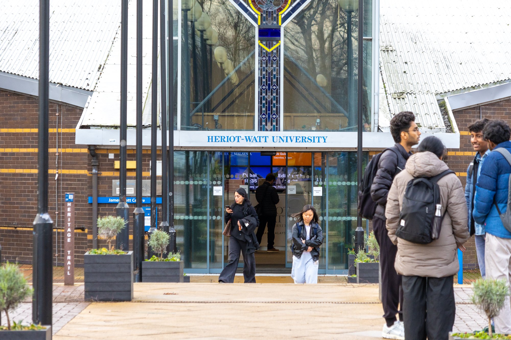 Individuals standing at an entrance to a building.