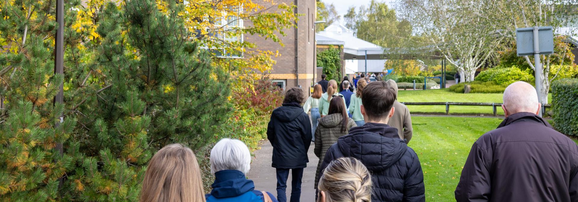 Individuals walking towards an event on Edinburgh campus