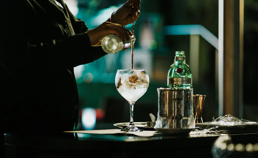 Pouring a gin. Photo by Bjarne Vijfvinkel on Unsplash.