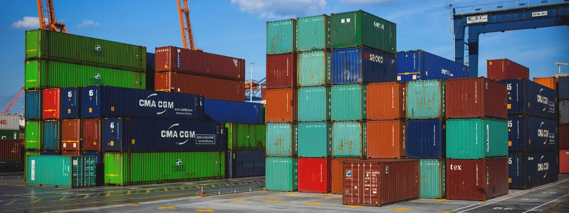 Stacks of shipping containers at a busy port.