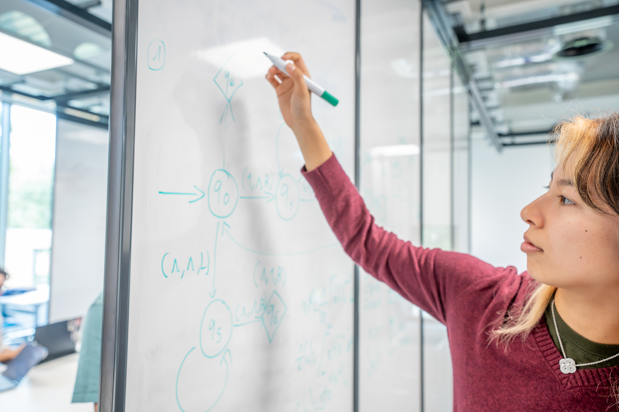 Student writing on a whiteboard
