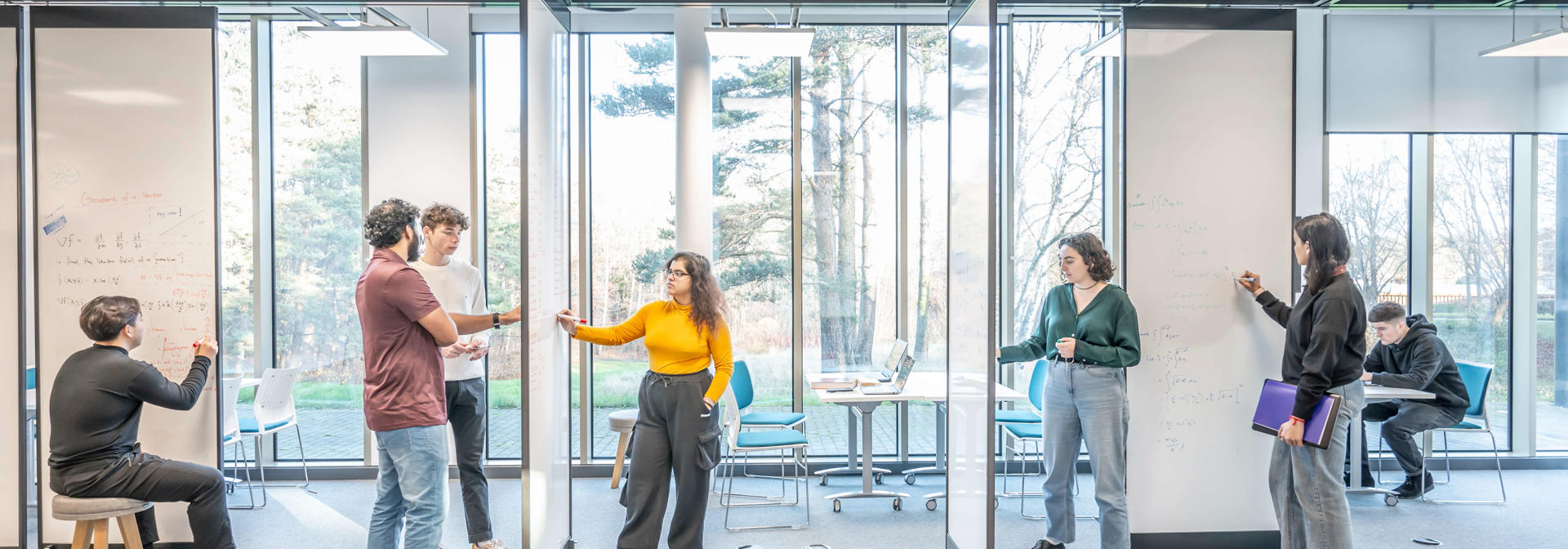 Students working on whiteboards in the open plan GRID Building, Edinburgh Campus