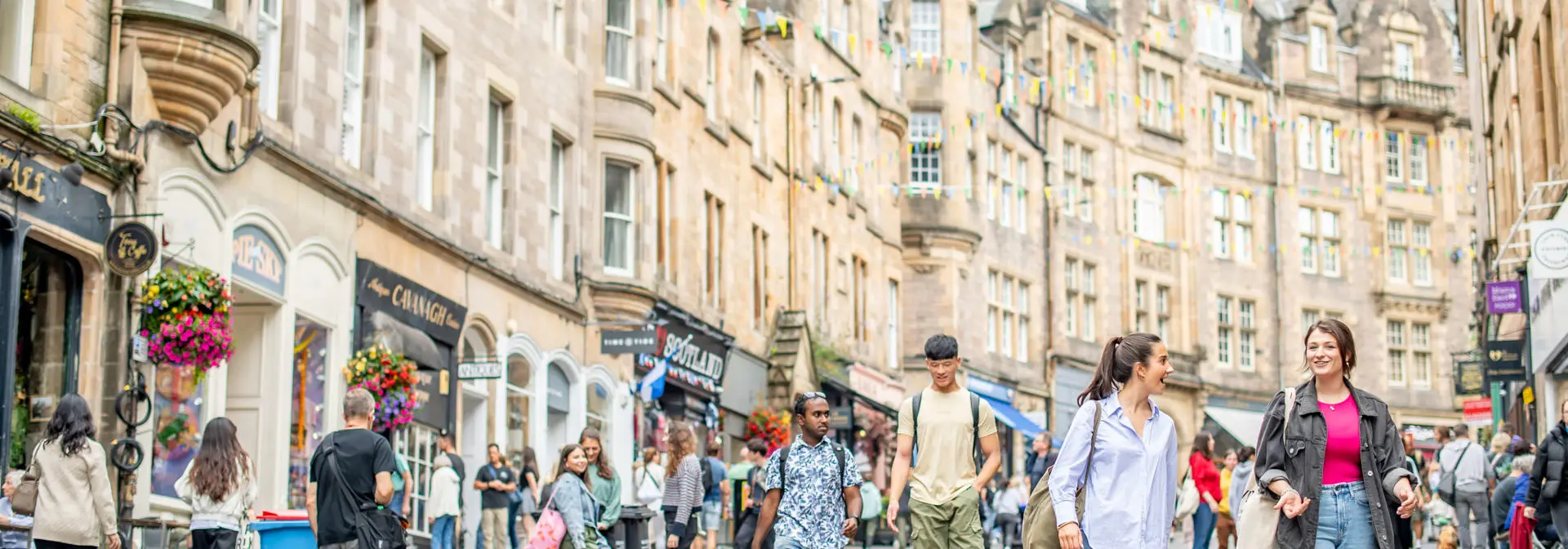 Many people walking together through Victoria Street in Edinburgh.