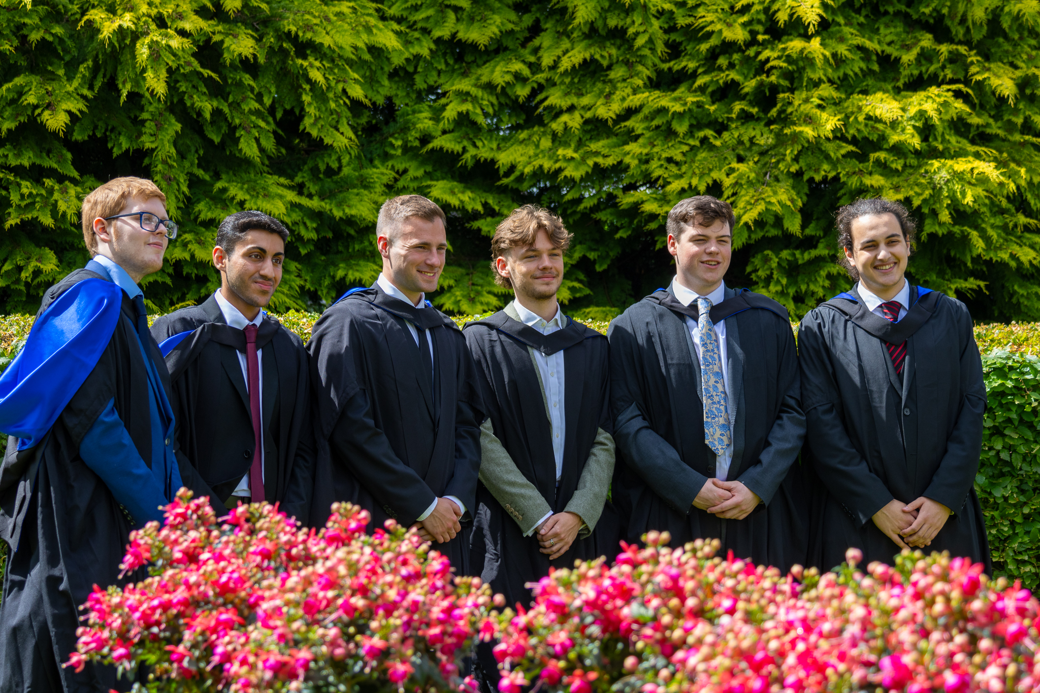 Six undergraduate graduates posing for photographs on Edinburgh campus.