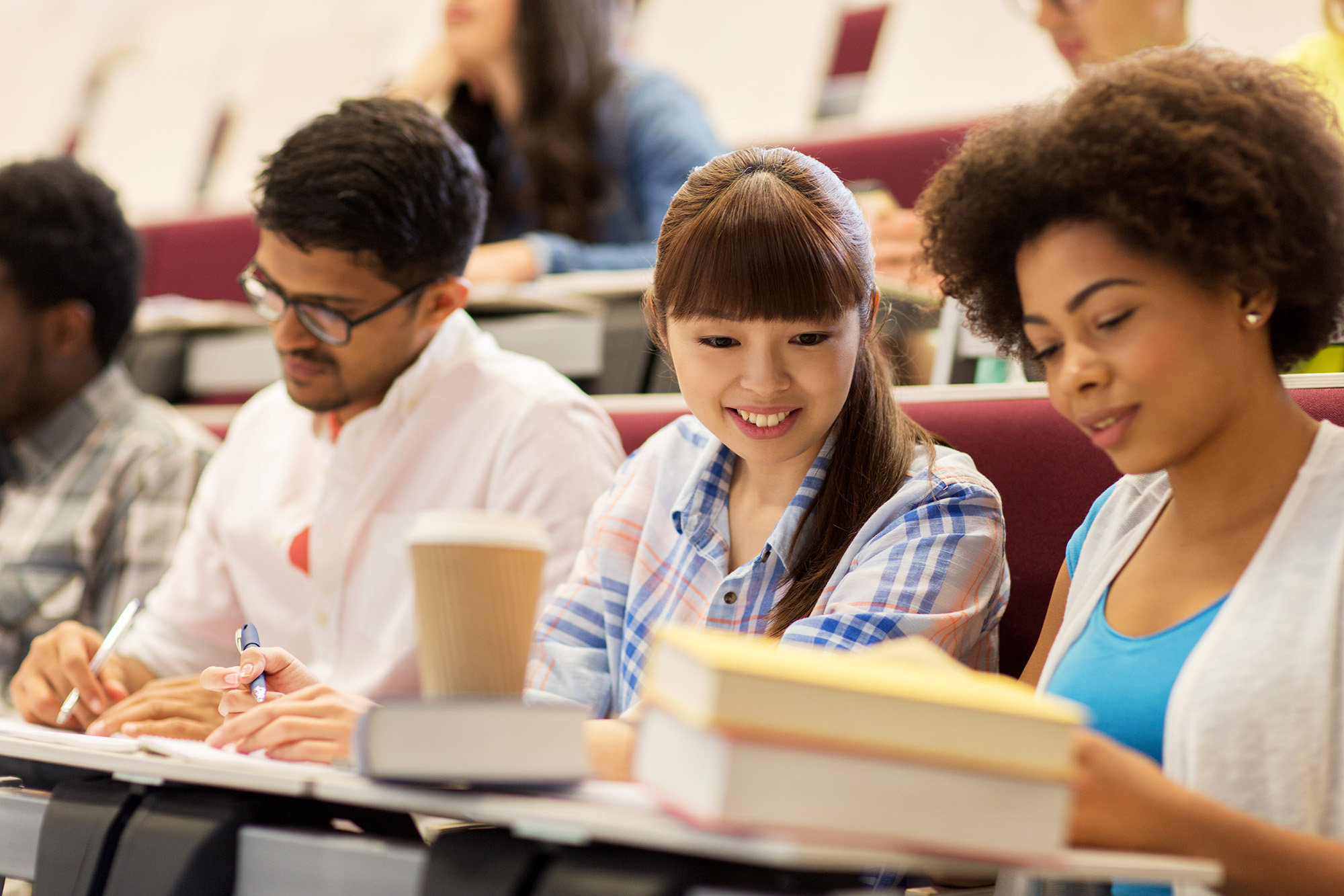 Three students in a lecture hall.