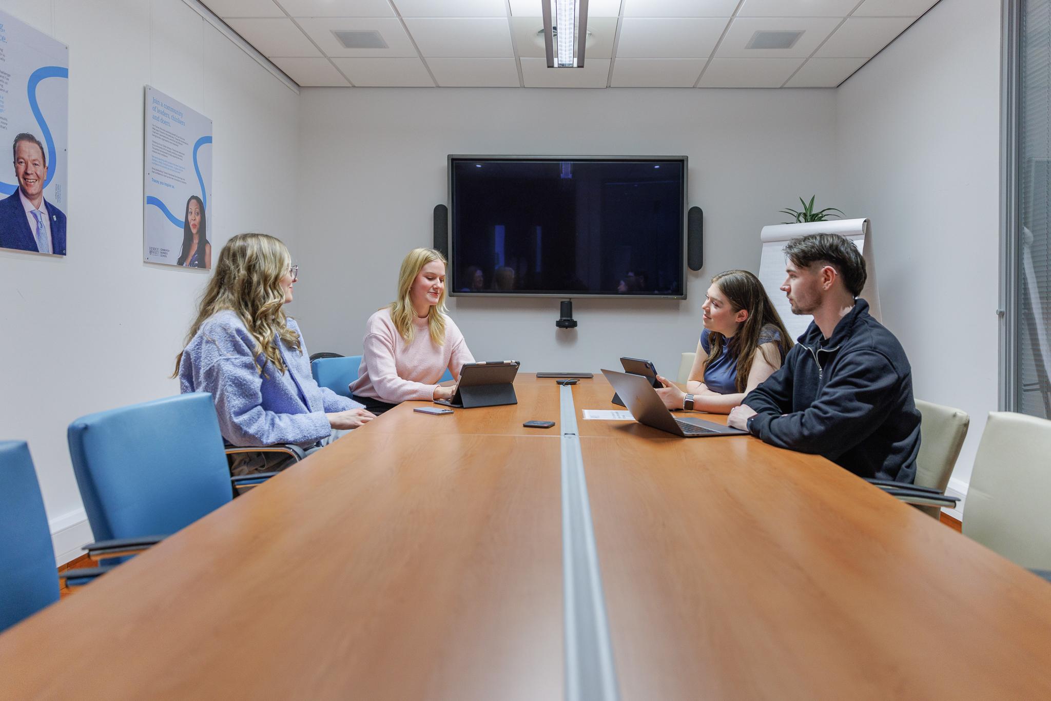 Four students sitting in the main meeting room of EBS on the Edinburgh campus.